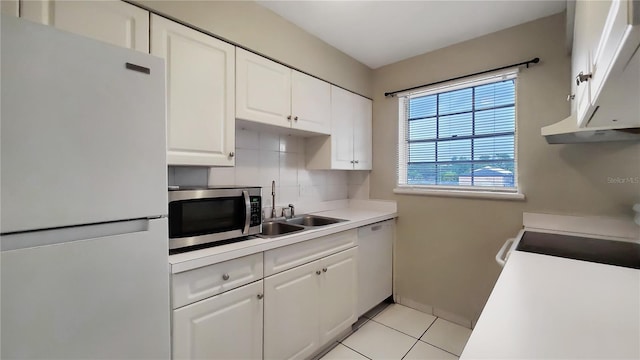 kitchen featuring sink, white cabinets, white appliances, backsplash, and light tile patterned floors