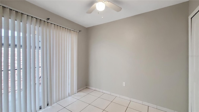 empty room featuring ceiling fan, light tile patterned floors, and plenty of natural light