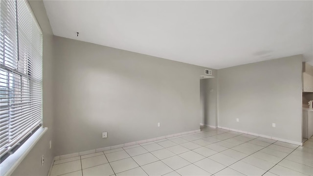 tiled spare room featuring plenty of natural light