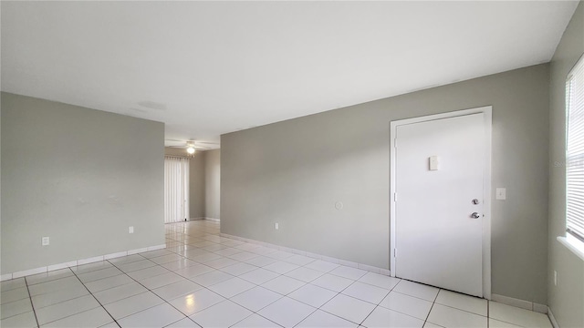 tiled empty room featuring ceiling fan