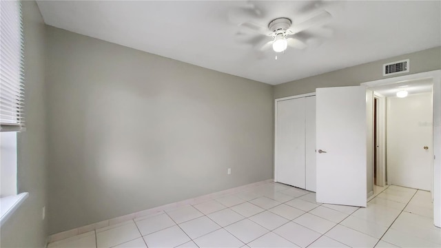 unfurnished bedroom with a closet, ceiling fan, and light tile patterned floors