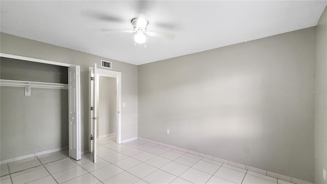 unfurnished bedroom featuring ceiling fan, a closet, and light tile patterned floors