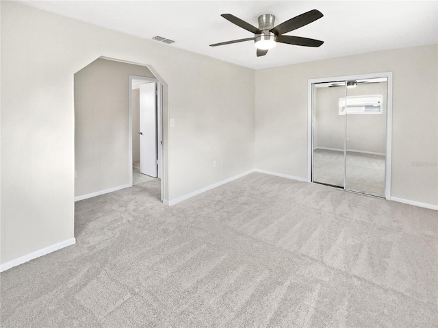 unfurnished bedroom with light carpet, a closet, and ceiling fan