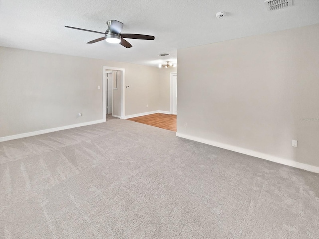 carpeted spare room with ceiling fan and a textured ceiling