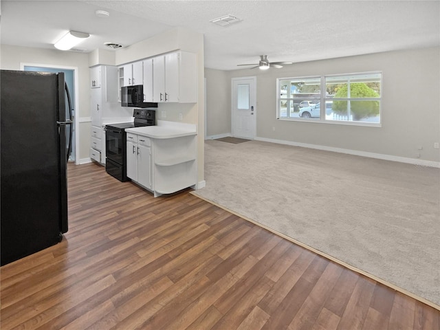 kitchen with white cabinets, black appliances, ceiling fan, and hardwood / wood-style floors