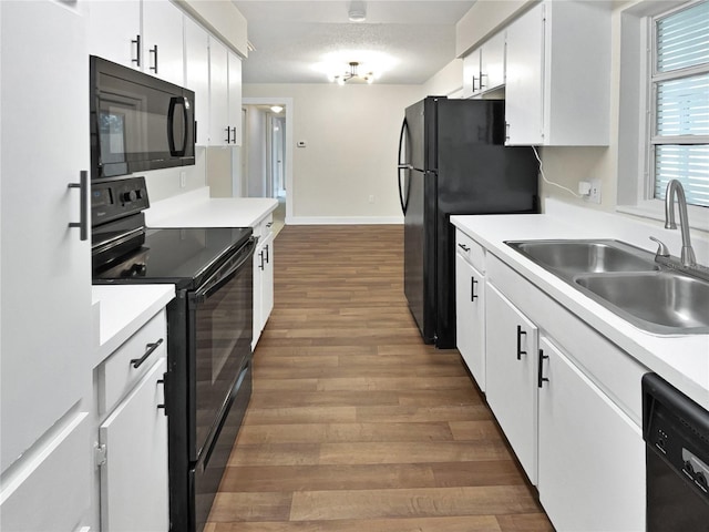 kitchen featuring dark hardwood / wood-style floors, sink, white cabinetry, and black appliances