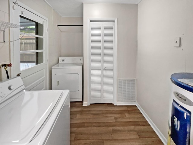 clothes washing area with dark hardwood / wood-style floors and washer and dryer