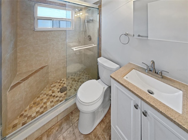 bathroom featuring vanity, toilet, tile patterned floors, and an enclosed shower