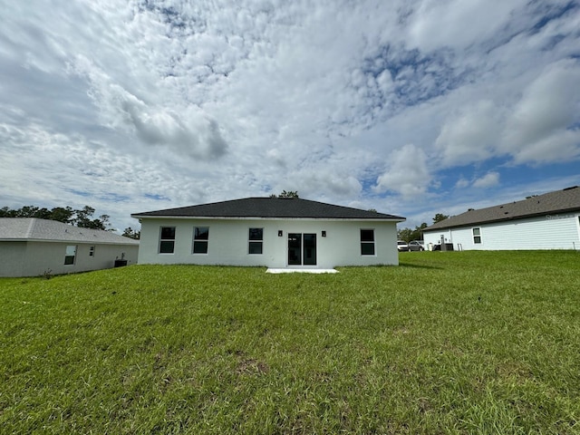 rear view of house featuring a yard