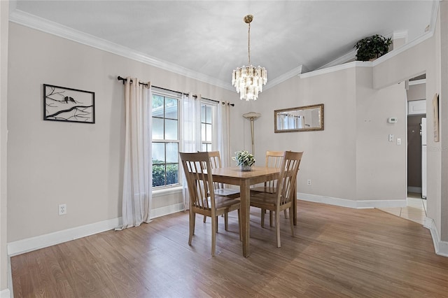 dining area featuring a chandelier, lofted ceiling, hardwood / wood-style flooring, and ornamental molding