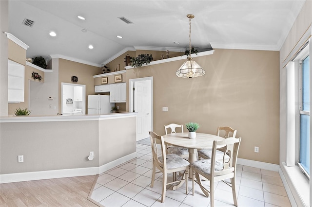 dining space featuring light hardwood / wood-style floors, lofted ceiling, and ornamental molding