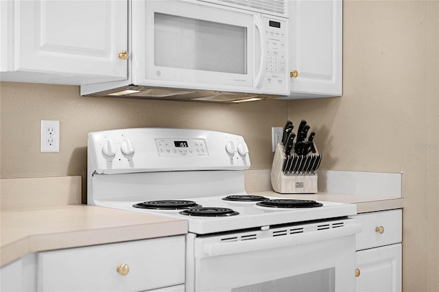 kitchen with white cabinets and white appliances