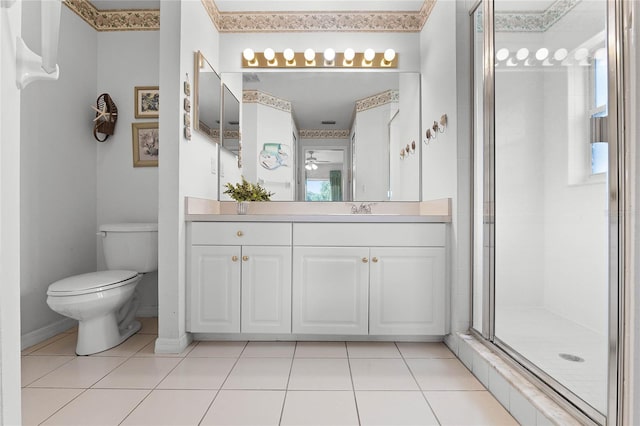 bathroom featuring ceiling fan, tile patterned flooring, toilet, vanity, and a shower with shower door