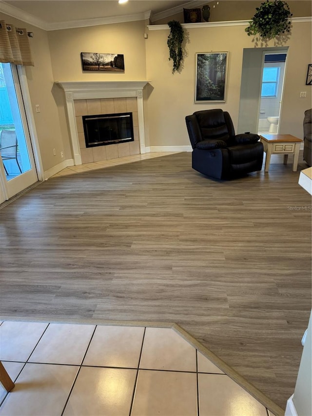 unfurnished living room featuring tile patterned flooring, ornamental molding, and a tiled fireplace