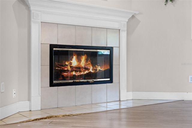 interior details with a tiled fireplace and hardwood / wood-style flooring