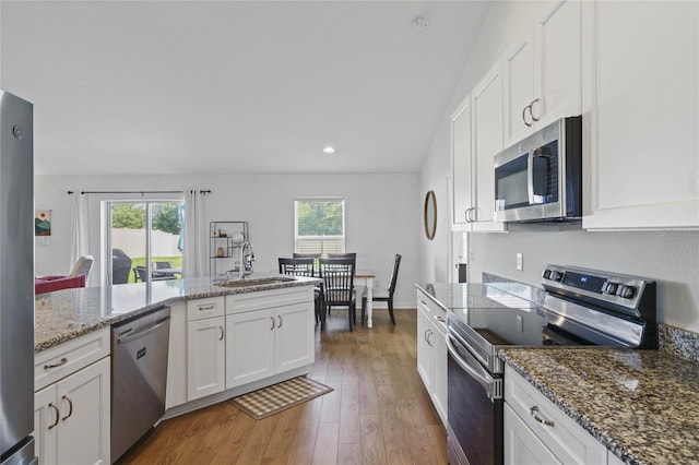 kitchen featuring dark hardwood / wood-style floors, a wealth of natural light, stainless steel appliances, and white cabinets