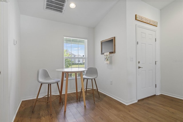 dining area with wood-type flooring and lofted ceiling