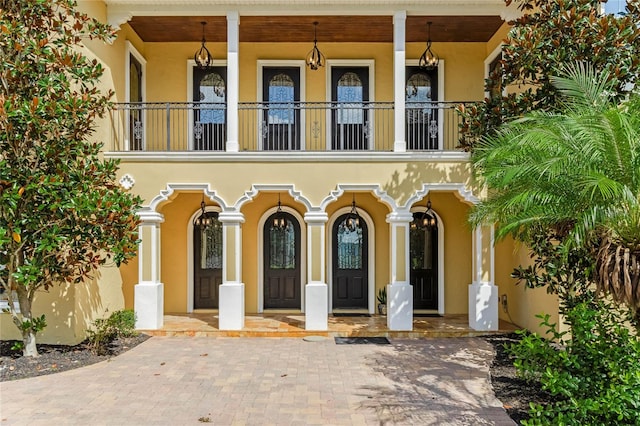 doorway to property with a balcony and a porch