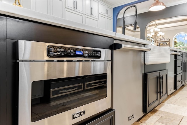 kitchen featuring white cabinets, hanging light fixtures, and crown molding