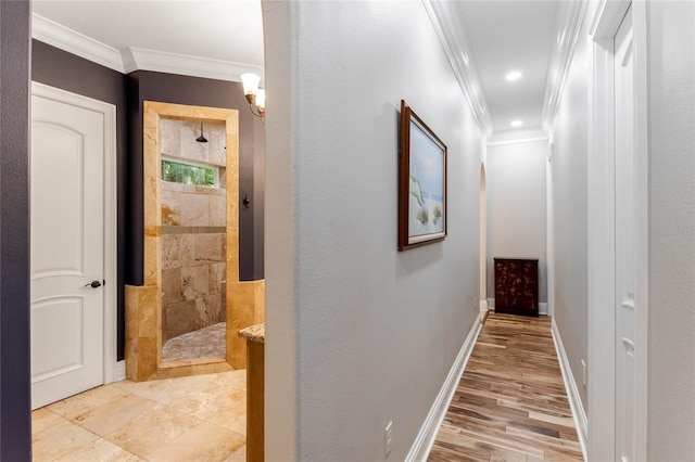 hallway with ornamental molding and light hardwood / wood-style flooring