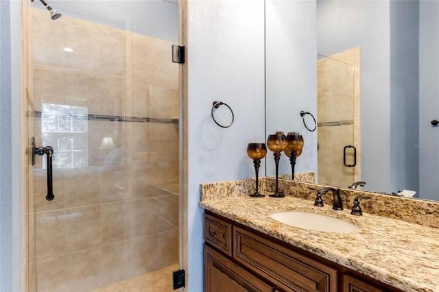 bathroom with a shower with door and vanity