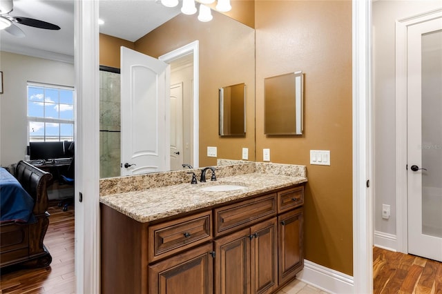 bathroom featuring ornamental molding, vanity, ceiling fan, and hardwood / wood-style flooring