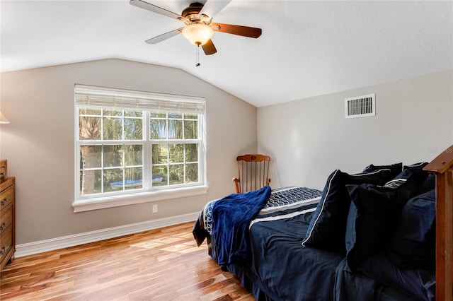 bedroom featuring ceiling fan, light wood-type flooring, and vaulted ceiling