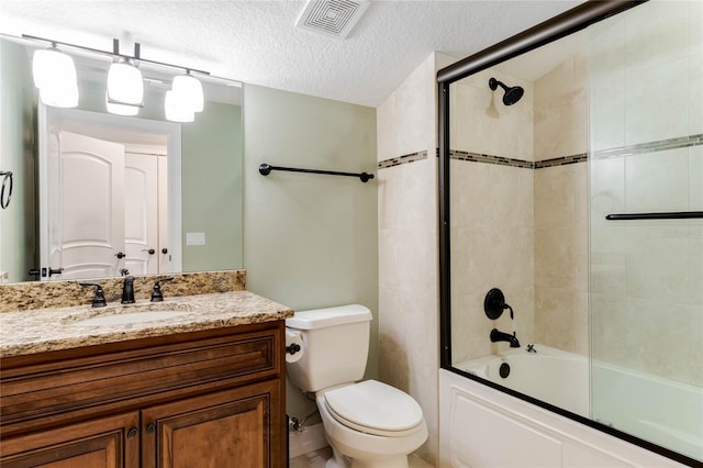 full bathroom with enclosed tub / shower combo, vanity, toilet, and a textured ceiling