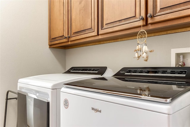 laundry area with a notable chandelier, washer and clothes dryer, and cabinets