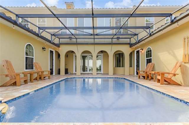 view of swimming pool featuring a patio and glass enclosure