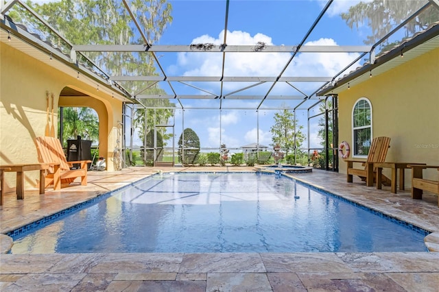 view of swimming pool with glass enclosure and a patio