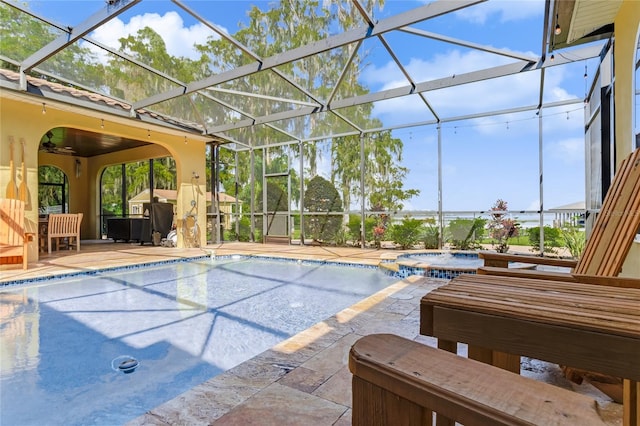 view of pool featuring glass enclosure, an in ground hot tub, and a patio area