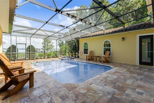 view of pool with glass enclosure, an in ground hot tub, and a patio