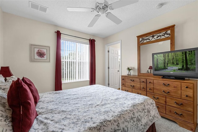 carpeted bedroom with a textured ceiling and ceiling fan