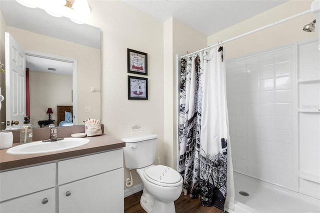 bathroom featuring a shower with shower curtain, wood-type flooring, vanity, and toilet