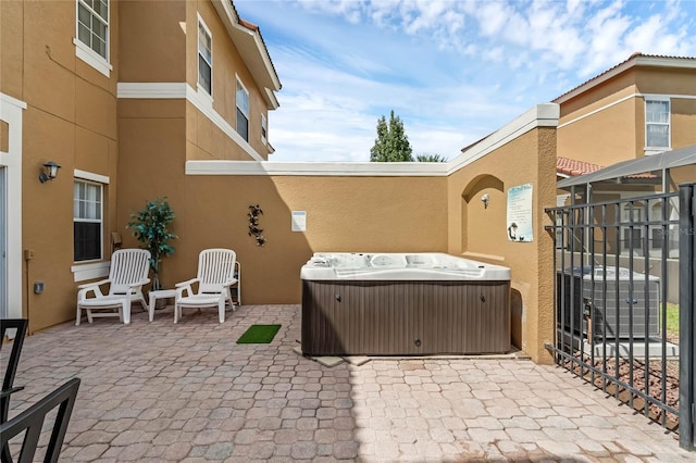 view of patio with a hot tub and central AC