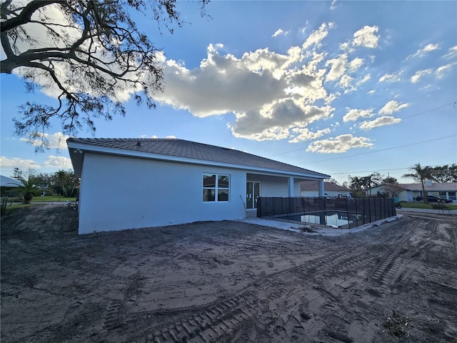 back of house with a swimming pool and a patio