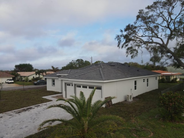 view of home's exterior featuring a garage and a lawn