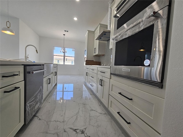 kitchen featuring stainless steel appliances, white cabinetry, wall chimney exhaust hood, decorative light fixtures, and a notable chandelier