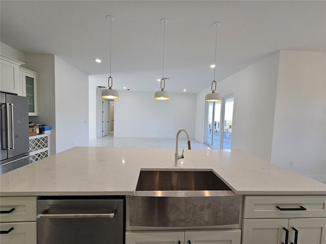 kitchen featuring sink, an island with sink, and light stone countertops