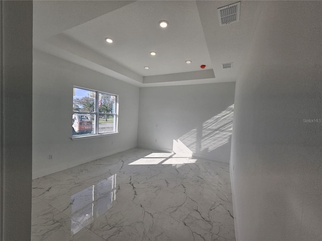 unfurnished room with a raised ceiling