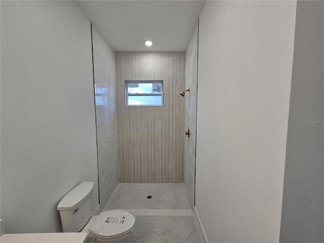 bathroom with toilet and tiled shower