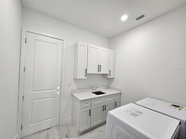 laundry area with cabinets, sink, and washer and dryer