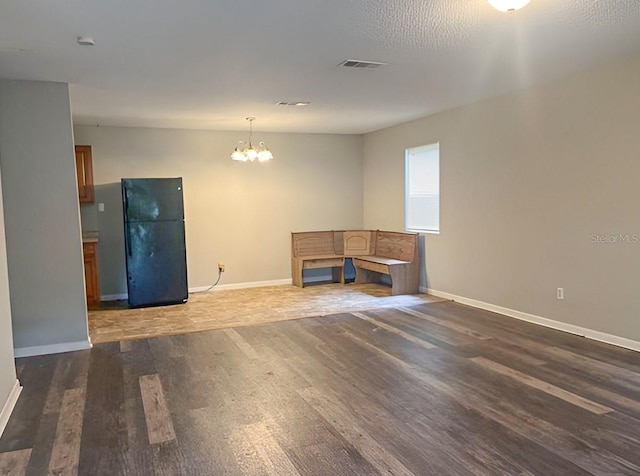 empty room featuring an inviting chandelier and dark wood-type flooring