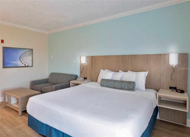 bedroom with a textured ceiling, light wood-type flooring, and crown molding