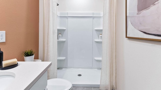 bathroom with walk in shower, vanity, and toilet