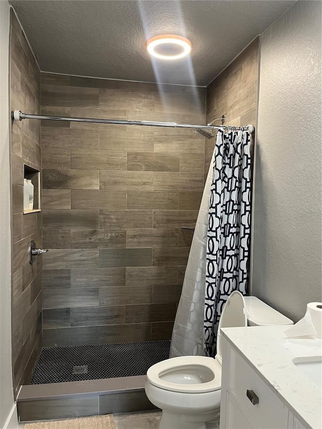 bathroom featuring vanity, a textured ceiling, toilet, and a shower with shower curtain