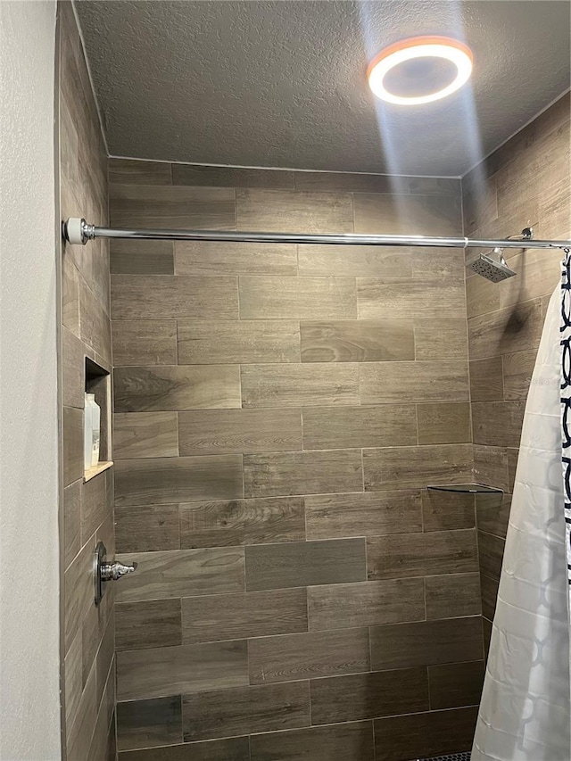 bathroom featuring curtained shower and a textured ceiling