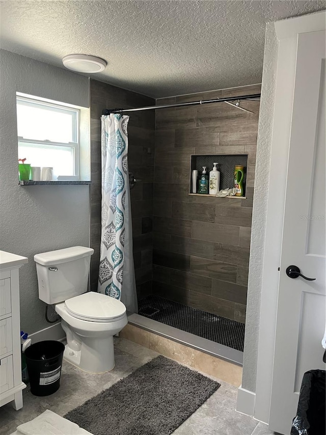 bathroom featuring vanity, toilet, a textured ceiling, and a shower with shower curtain