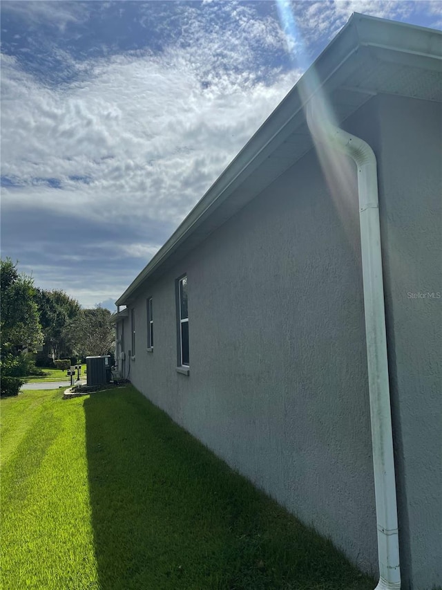 view of property exterior featuring a yard and central AC